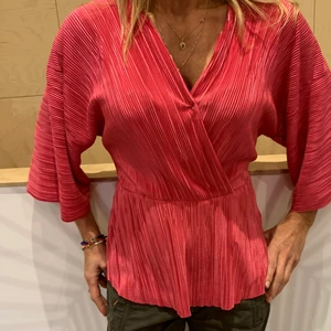 Rosa blus 👚 stretchig - Super skön, snygg och bekväm Rosa/coral färgad blus i bra skick! 💝💖 Jag använder en säkerhetsnål vid bysten men det är bara för jag tyckte den satt snyggare då!:) 