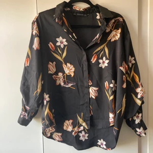Silkesskjorta - Snygg skjorta utav silke från Zara. Stora blommor dekorerar fram och baksida. Säljer då den inte passar min stil. Puffiga ärmar