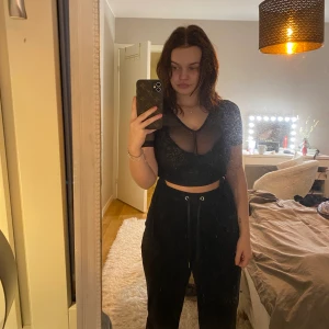 Svart mesh t-shirt med knytning - Säljer en svart t-shirt i mesh som är rätt så genomskinlig. Har jättefin knytning på båda sidorna som gör att man kan välja hur lång eller kort man vill att den ska vara. Från Asos i stl xs. Knappt använd