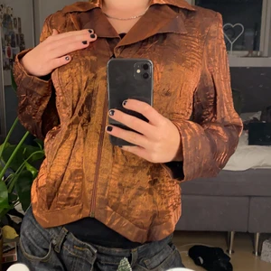 Bronsfärgad jacka - Säljer denna as balla bronsfärgade jacka med dragkedja. Den är både snygg öppen och knäppt. Funkar både att klä ner men även att klä upp och ha till fest❤️köpt secondhand men knappt annvänt så i väldigt bra skick.❤️❤️