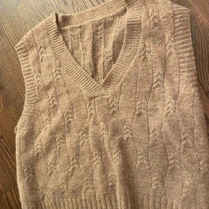 Rosa/brun stickad väst - Färger framgår inte helt i bilderna men den är brun med lite rosa i färgen. 