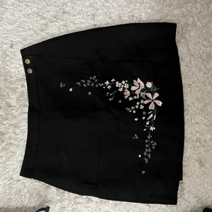 Kjol, prislapp kvar - Kjol i mocka i omlott model och med fina broderier, tyvärr inte kommit till användning 