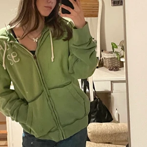 Zip up hoodie - En starkt grön oversized hoodie med mörkgröna sömmar från abercrombie & fitch. Den är i slitet skick med många defekter vilket passar bra till stilen. Tjockt och skönt tyg. Bara att fråga om du vill ha fler bilder! (Intresse koll)