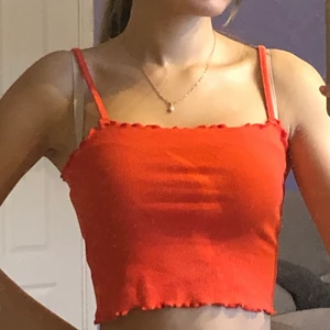 röd crop top linne - röd crop top med ruffels uppe och nere. väldigt stretchigt material.