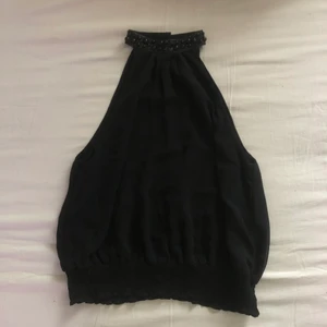 Festlinne - Världens finaste festlinne! Halsen är smyckad med pärlor i svart. Stängs med krokar i nacken. Märkt 40 men sitter snyggt på mig som bär S