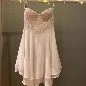 Vit kort klänning te amo - +50 för frakt. Vit kort klänning korsettliknande med dragkedja på ryggen. Broderad spets överdel med paljetter. Klänningen är vadderad men ingen bygel, och kupan skulle jag säga är runt A, B. Står storlek 10 vilket är ungefär 36