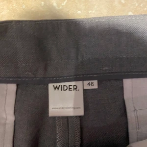 Breda kostymbyxor (gråa) - Ett par breda kostymbyxor från Wilder Clothing. Storlek 46. Passar mig som är cirka 1,83 cm lång. Är slutsålda på deras hemsida där nypriset är 900kr. Använda en gång. Skick 10/10