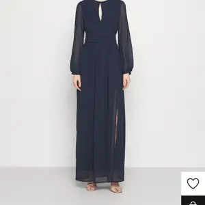 Mörkblå långklänning beställd på Zalando. Aldrig använd och har taggen kvar, säljer pga fel storlek. Nypris 779 kr. Slits på benet och cutout vid halsen. Perfekt som balklänning eller liknande!