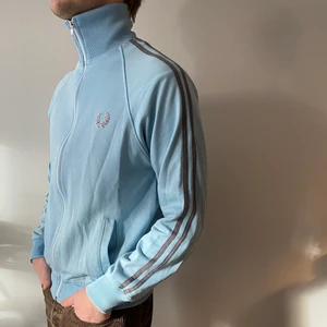 Vintage Fred Perry track jacket strl S - Vintage ljusblå Fred Perry tröja med blixtlås i storlek S. Sparsamt använd. Mycket fint skick.