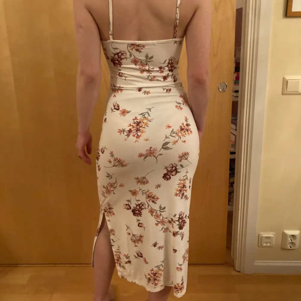A white snug and stretchy dress that fits curves perfectly. Pretty pink flower patterns and an open back as well as a slit on the side. One size. Used only 2 times. . Klänningar.
