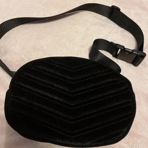 Bältesväska  - Jag säljer denna bältväskan som man kan ha runt midjan men också vid bröstet, den är i jätte bra skick även om jag har använt den en hel del gånger mest för att den är svart men också för att den har ett sammet matrial vilket gör att den också ser mycket dyrare ut. Justerbara band så borde passa alla. (Köparen står för frakten men kan mötas upp i Malmö) 