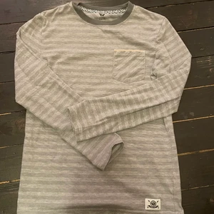 Långärmad randig tröja  - Ett bra basplagg, randig och långärmad:)) passar bra, lite för liten för mig. Ganska oandvänd och i bra skick. Lätt att styla och cool att ha med t.ex mycket smycken och assessorer. Märket är av en känd snowboard åkare ”Shaun white” 