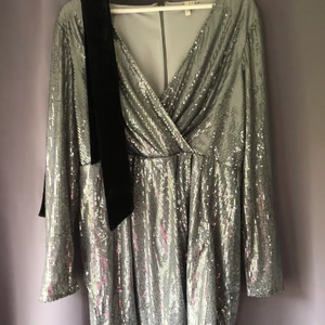 Klänning  - Säljer min fina glitter klänning från Nelly, med ett fint sidenband till som jag fick med när jag köpte klänningen. Använd 1 gång. O storlek 42/L 