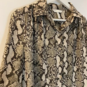 Ormmönstrad skjorta - Ormmönstrad tunn skjorta från H&M! 🐍 Sitter löst och är lite längre baktill. Storlek 34 men skulle passa en som är 36 också! Har endast blivit använd 2 gånger så den är näst intill nyskick 🤍 Köparen står för frakt 🌸