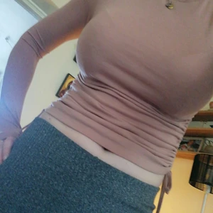 Topp från Bershka strl. M - Rostbrun färgad tight topp med strech från märket Bershka med knytning i sidorna, som går att göra kortare eller längre enligt egen smak. 