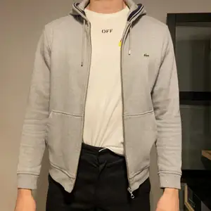 Säljer nu min gråa Lacoste hoodie med dragkedja då den blivit för liten. Mycket fint skick! Nypris: 1200kr