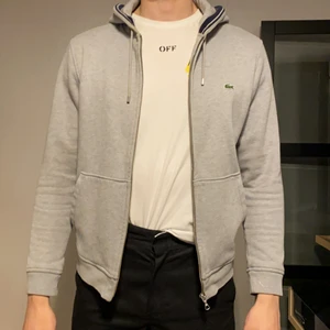 Lacoste hoodie - Säljer nu min gråa Lacoste hoodie med dragkedja då den blivit för liten. Mycket fint skick! Nypris: 1200kr