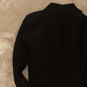 Svart polotröja  - En helt vanlig svart ribbad polotröja, storlek XS, dålig bild men bara att skriva om man skulle vilja ha fler bilder!