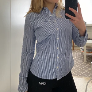 Randig skjorta från A&F - En blå/vitrandig skjorta från A&F. Sparsamt använd och i mycket bra skick. Säljer då jag gymmat så att armarna inte längre får plats😉 kan skicka fler bilder vid behov! 