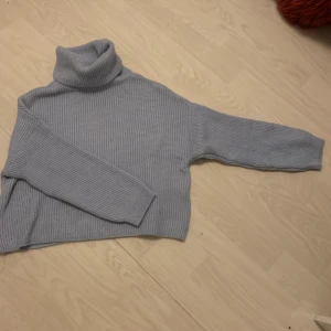 Stickad ljusblå polotröja - Aldrig använt, säljer då den bara hänger i garderoben. Aningen tajt runt halsen, på bilden är kragen dessutom dubbelvikt då den är ganska lång. Ganska kort i ärmarna. 