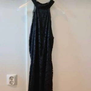 Festklänning i spets från Nelly strl S. - Lång figursydd festklänning i svart spets från Nelly strl S som är använd vid ett tillfälle.