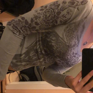 tight tröja med tryck - Super fin grå tröja med tryck, vingar osv. Säljer för jag råkat köpa två likadana. Storlek S men ganska tight skulle passa XS väldigt bra. Tyget är inte så strechigt.