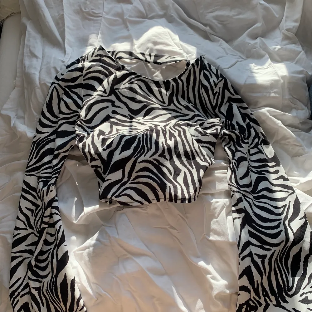 Supersnygg kort zebra tröja, med långa flared armar och en öppen rygg. Använd bara ett fåtal gånger. Köpare står för frakten! 💛🌼💛🌼. Toppar.