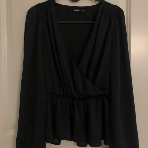 Svart blus i siden - En svart blus från bikbok i siden, oanvänd.