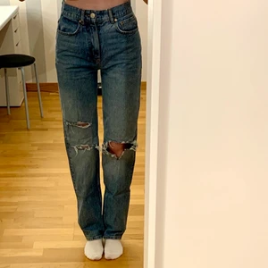 Blå jeans - Blå jeans med hål på knäna i en 90-tals modell från gina tricot. Säljer då jag inte använder dem längre. Jag är 172 cm. Köpare står för frakt.