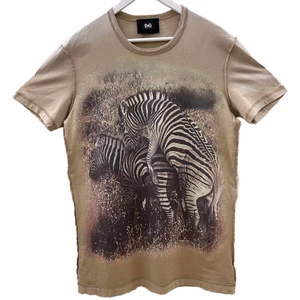 Dolce & Gabbana T-shirt - Ett collector-item från Dolce & Gabbana som man kunde få tag på Dolce Tanzania resan som hölls för några år sedan. T-shirten är i storlek 50, vilket motsvarar storlek M. Meddela mig gärna ifall ni vill ha fler bilder och bilder på hur den sitter på mig. Den har inga skador över huvud taget. Jag kan skicka den ifall köparen står för frakt eller mötas upp i Stockholm.