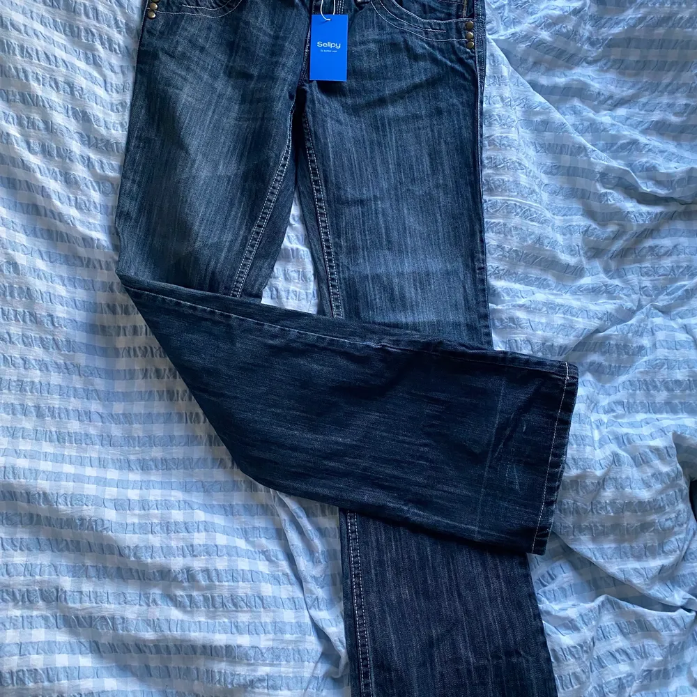Ett par jättenajs mörkblåa lågmidjade Bootcut jeans, som tyvärr var för små för mig. Köpta från sellpy, men i väldigt bra skick! Midjemåttet är 78 cm och skulle säga att dem passar någon runt 170.. Jeans & Byxor.