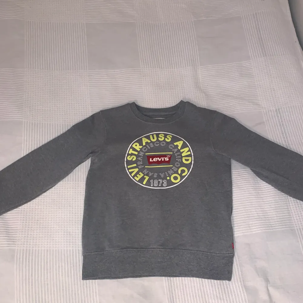 Jättesnygg grå sweatshirt med tryck ifrån Levis. Den är i nyskick och använd en gång. Köparen står för frakten.. Tröjor & Koftor.