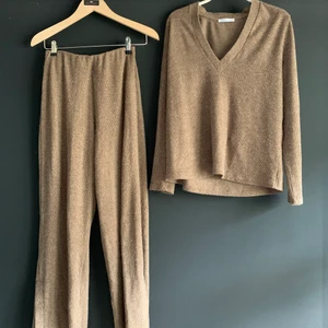 Stickat set från Zara - Ett snyggt stickat det från zara i beige färg. Byxorna har slits längst ned och tröjan är v ringad. Sparsamt använd och i fint skick. Stl s i byxan, m i tröjan. Köparen står för frakt.