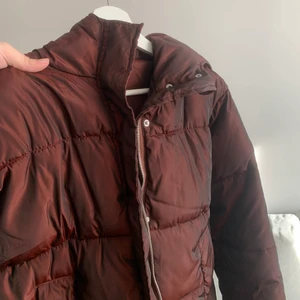 Röd vinterjacka - Röd vinterjacka/pufferjacket i storlek 34, S-M. från NAKD (med luva). Den är skimrig/liknande reflex. Sparsamt använd och mycket bra skick. Kan mötas eller skickas med Postnord skicka lätt.