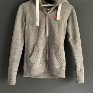 Luvtröja från superdry  - Sparsamt använd luvtröja med dragkedja från superdry. Stl S i grå färg. Mycket fint skick. Köpare står för frakt.