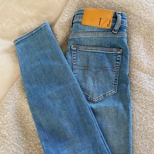  Jeans från Tiger of Sweden - Säljer dessa tighta blåa jeans från märket tiger of sweden. De är i storlek 27 men upplever de som mindre i storleken. De har tyvärr blivit för små för mig så de kommer inte till användning längre. De är i gott skick! Frakt tillkommer om inte annat är överenskommet. 
