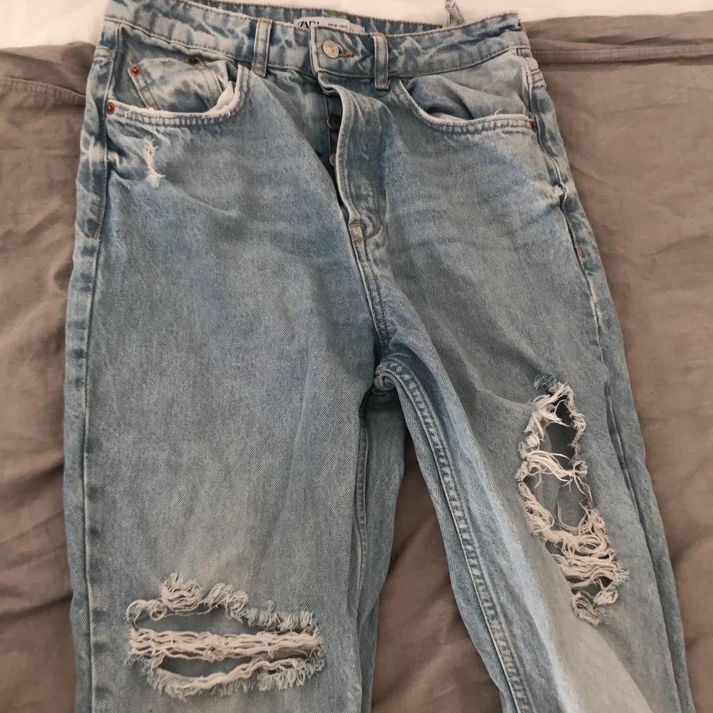 Snygga slitna jeans från zara, straight fit kan man säga. Fin ljusblå färg med slitningar lite överallt. Storlek 38. Köparen står för frakten.. Jeans & Byxor.