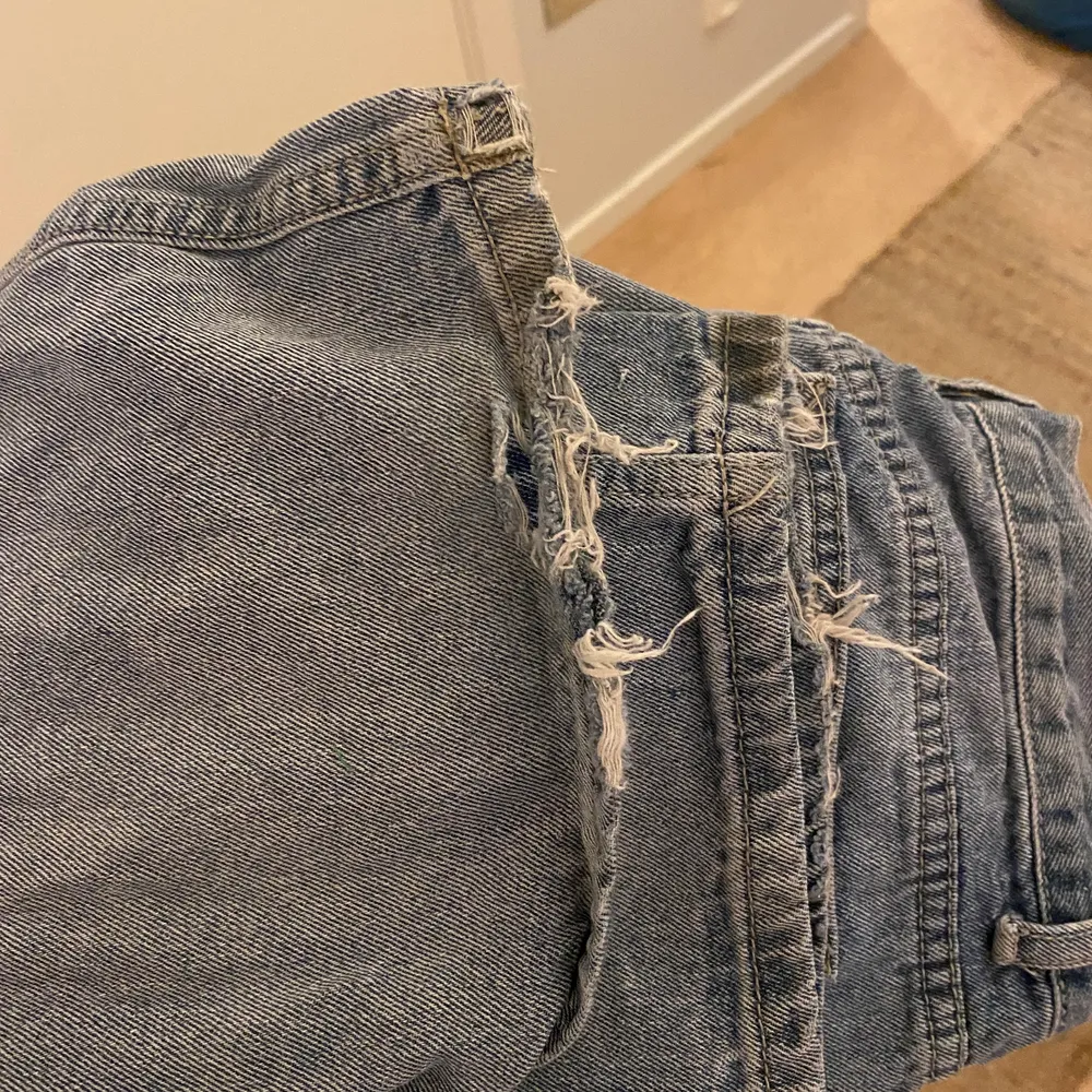 Jeans från Boohoo i storlek 36. Jeansen har stora hål och slitningar nere vit byxbenet. . Jeans & Byxor.