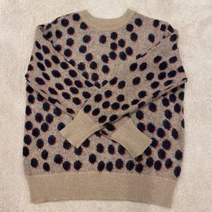 En stickad tröja i leopard mönster. Storlek L 