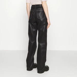 Svarta glansiga jeans - Supersnygga svarta glansiga jeans med vita sömmar från Topshop som är helt slutsålda, påminner om Eytys Cypress Tar jeansen💗 Storlek W30 L32 men sitter snyggt oversize och lågmidjat på mig som brukar ha W26 L32, kan skicka bild om det önskas💗💗