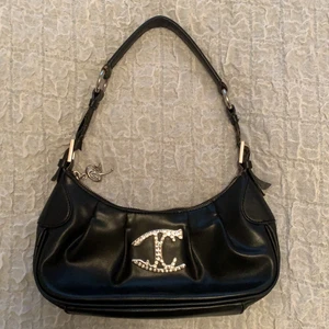 Just Cavalli handväska/baguette bag - Jättefin handväska/baguette bag från Just Cavalli! Den är sååå rymlig och passar verkligen till allt! Den är ganska sliten vid handtagen, och dragkedjan är lite seg. Går att justera längden på handtaget. Köpte secondhand. Köparen står för frakten annars kan jag mötas i Göteborg!! 💕