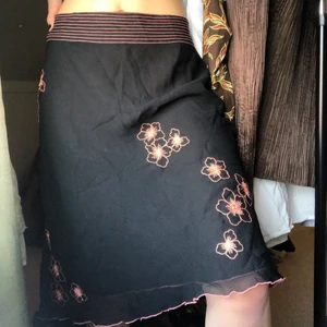 Kjol - Superfin svart kjol med fina orangea blom-detaljer! Storlek 36, bra skick!