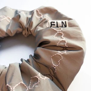 Reflexscrunchie med ljusrosa hjärtan - Scrunchie sydd av reflextyg broderad med ljusrosa hjärtan. Säker i mörkret eller bara asrejvig på festen!