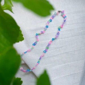 Pärlhalsband ”Pastellbukett” - PASTELLBUKETT är ett pärlhalsband som är ca 45cm långt. Den har en karbinhake som håller ihop smycket.