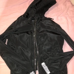 Tunn vårjacka - Svart ”vårjacka” väldigt tunn. Aldrig använd.  Köparen står för frakten!