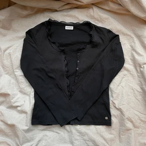 Långärmad topp  - Topp med knappar och volanger, strl står inte men skulle säga att den passar ca strl XS-M beroende på hur man vill att den sitter 🖤 Begagnat men fint skick! Fraktas spårbart för 51 kr 🦋