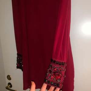 Röd Kläning med stenar - Super fin klänning med det lilla extra, använd runt 2 gånger då jag växte ur den.