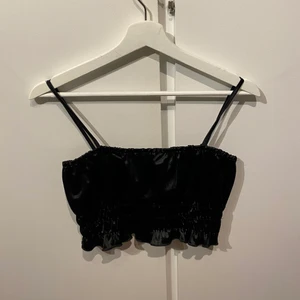Svart festtopp - En svart festtopp, köpt second hand men aldrig använd av mig. Storlek S, från Nelly. Ganska liten och kort. Jättefint glansigt tyg. 60kr + frakt 🤩