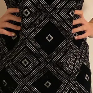 Rak klänning i svart sammet med glittriga romber, troligtvis från 60-talet. Passformen är som sagt rak, men kan kombineras med skärp eller liknande för att markera midjan om man så vill. OBS: ganska smal runt rumpan🌟