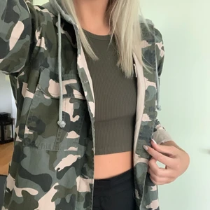 Camo jacka med luva  - Snygg oversized jacka i rosa/grön camo. Rymlig grå luva och bekvämt material. 4 fickor fram. Knappt använd. 